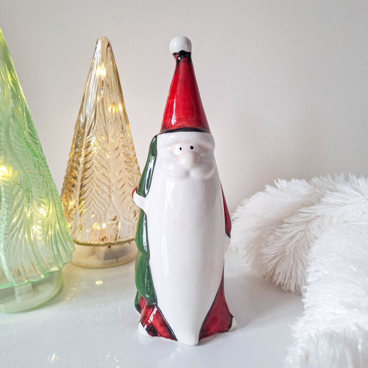 Red Santa Holding Christmas Tree